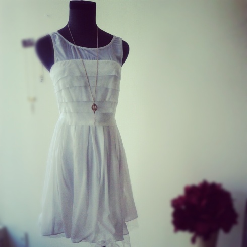 Tiered white ruffle dress with chiffon underlay. Necklace by KURVE.