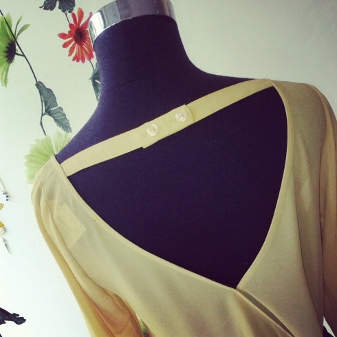 3/4 sleeve Mustard blouse has asymmetrical cut-out detail in back. Also featured in Kelly Green.